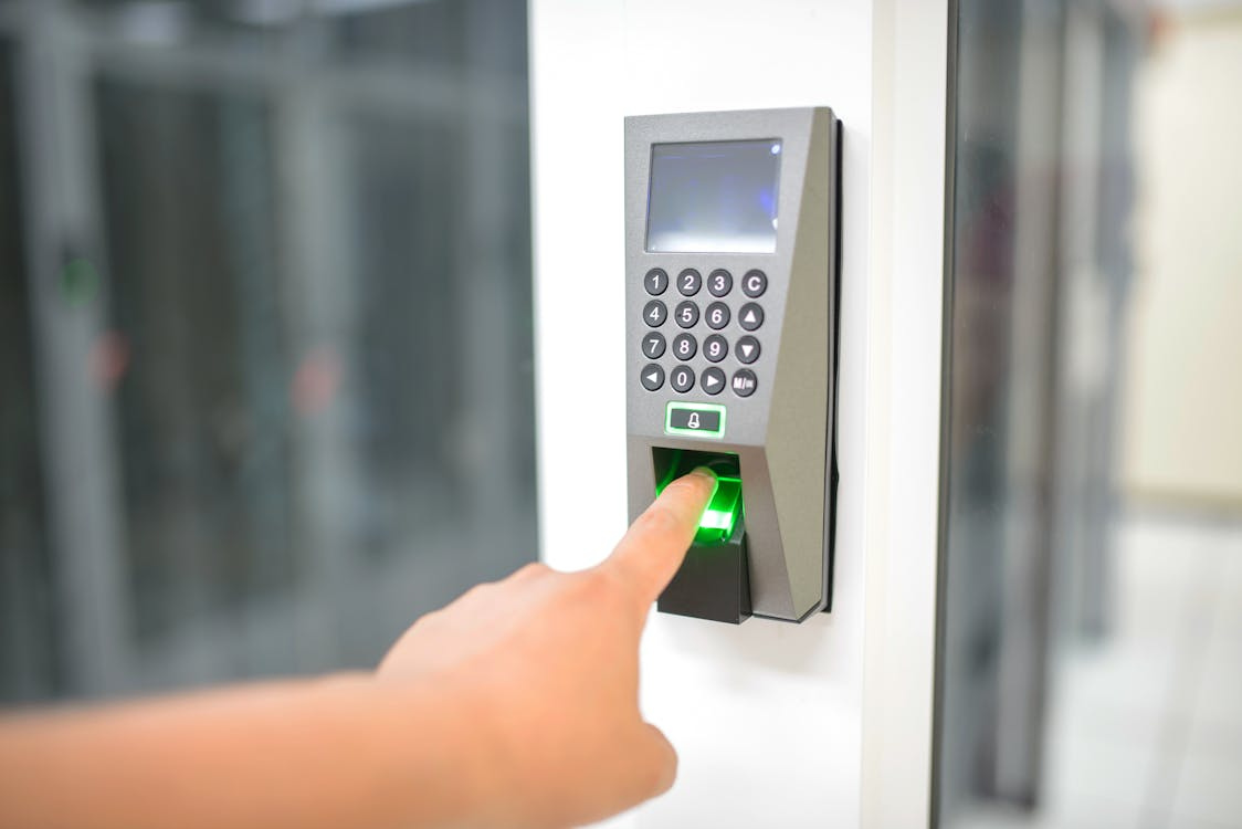 A person scanning their fingerprint on a biometric access control reader