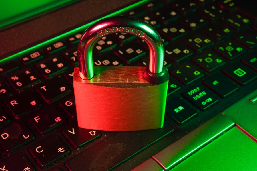 Metal padlock placed on a laptop keyboard representing digital and physical security protection