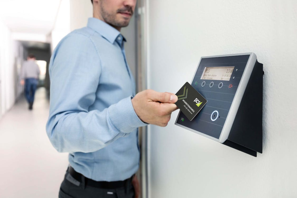 An employee tapping a smart card on an RFID door access control terminal